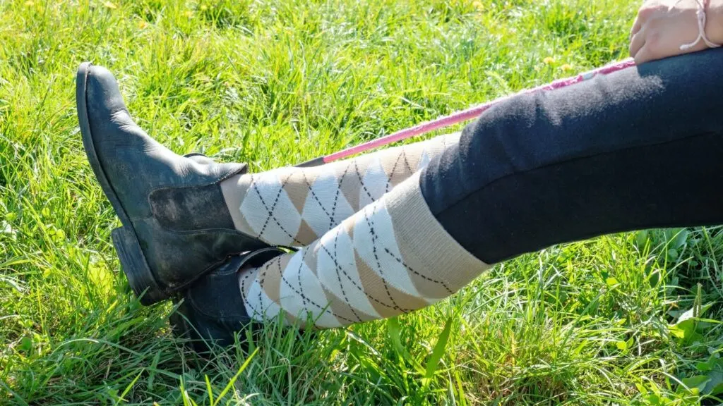 Imagen de las piernas de un jinete relajándose en un par de botas de paddock.