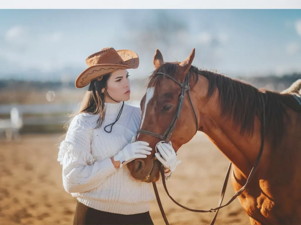 Imagen de una mujer que lleva un sombrero de vaquero con su caballo.
